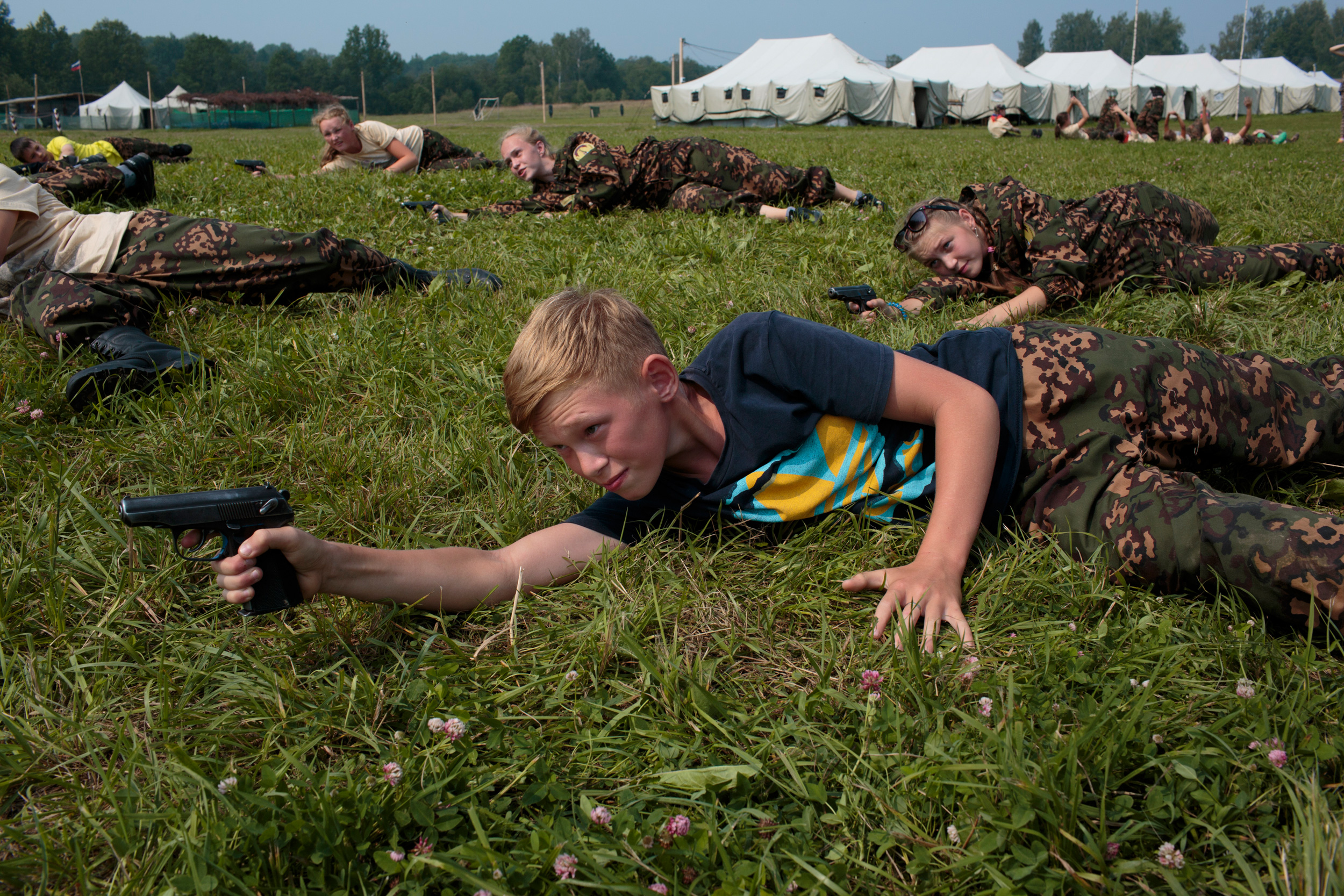 Students train in firearms at the Historical War Camp, in Borodino, Russia. July 24, 2016. Borodino is famous for a battle fought on September 7, 1812—the deadliest day of the Napoleonic Wars. Three hundred fifty adolescents are in attendance, ranging in ages from 11 to 16. They are using air-soft guns for the practice and competition. The camp teaches information about the basic kinds of weapons, bases and firing rules, sniper rifles, and different type of weapons. © Sarah Blesener