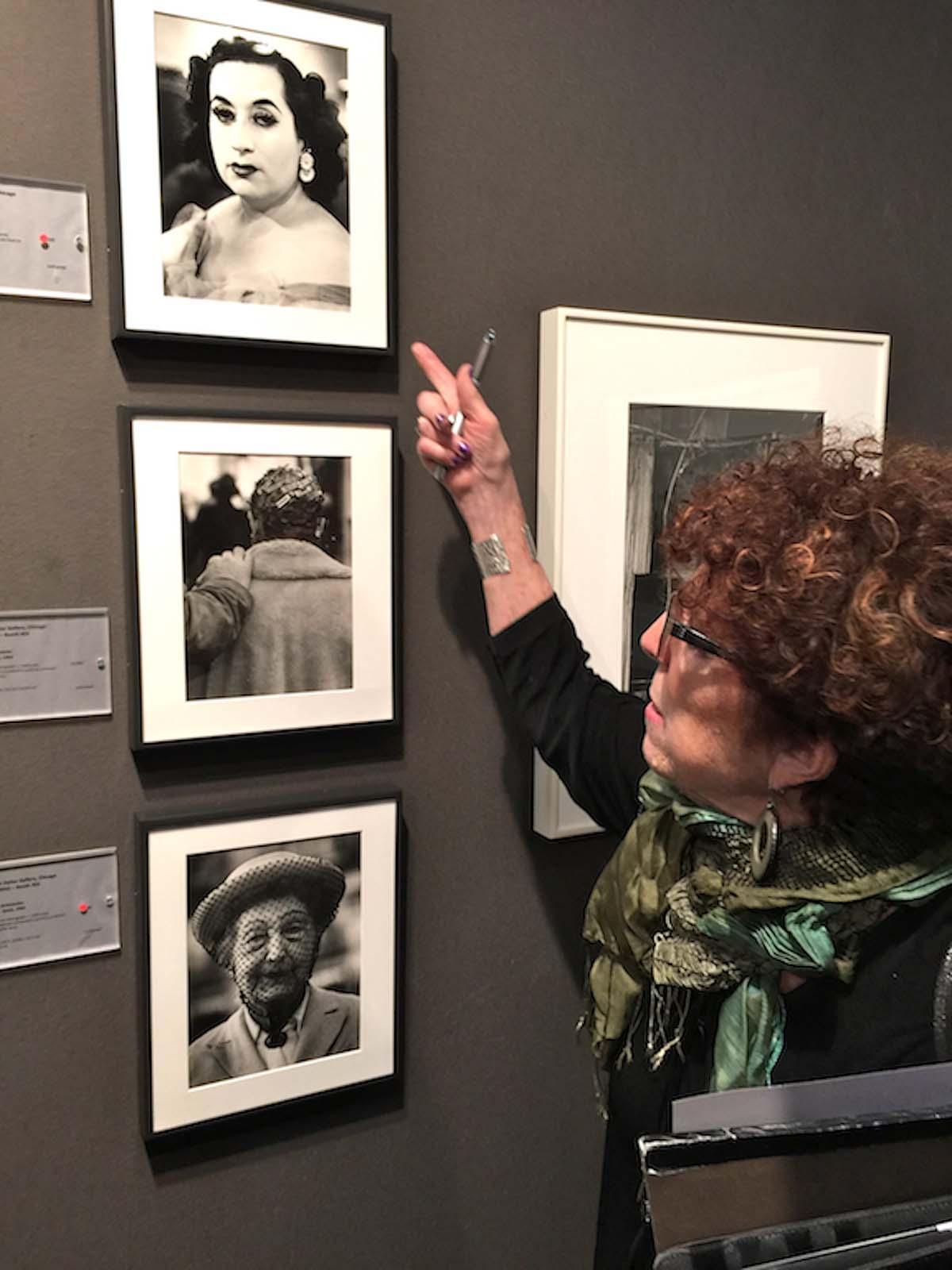 A woman looking at old photos on the wall.