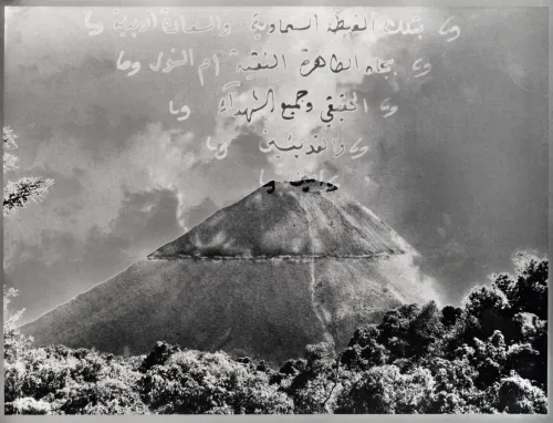 A black and white mountain with arabic superimposed over it. 