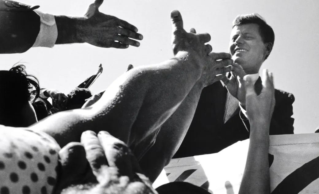 John F. Kennedy shaking hands with a crowd of people
