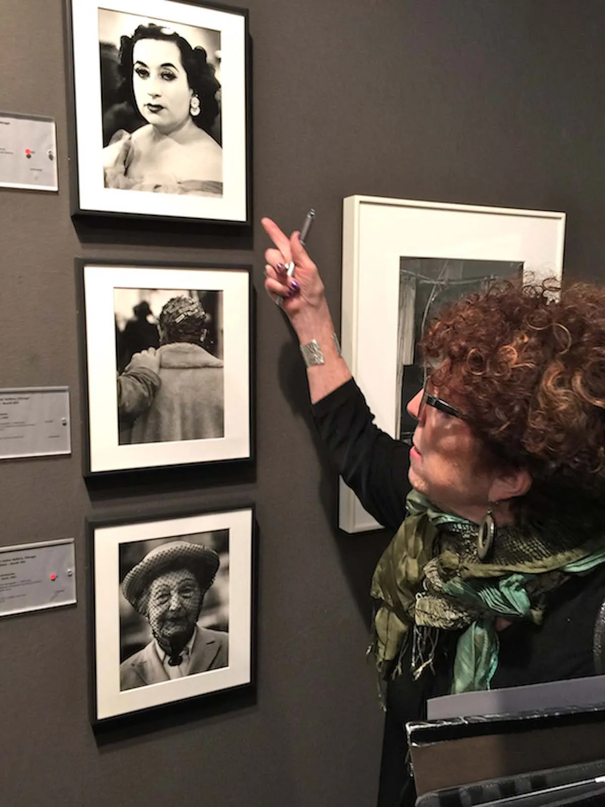 A woman looking at old photos on the wall.