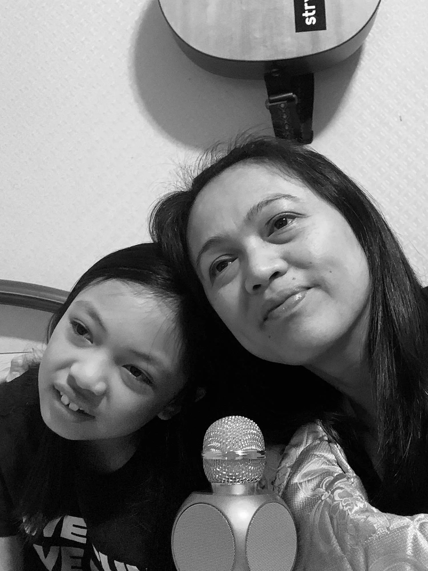 A picture of a mother and daughter with a microphone.