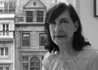 A picture of a woman next to the window.