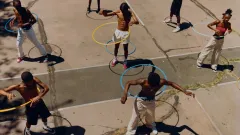 Kids outside playing with a hula hoop.