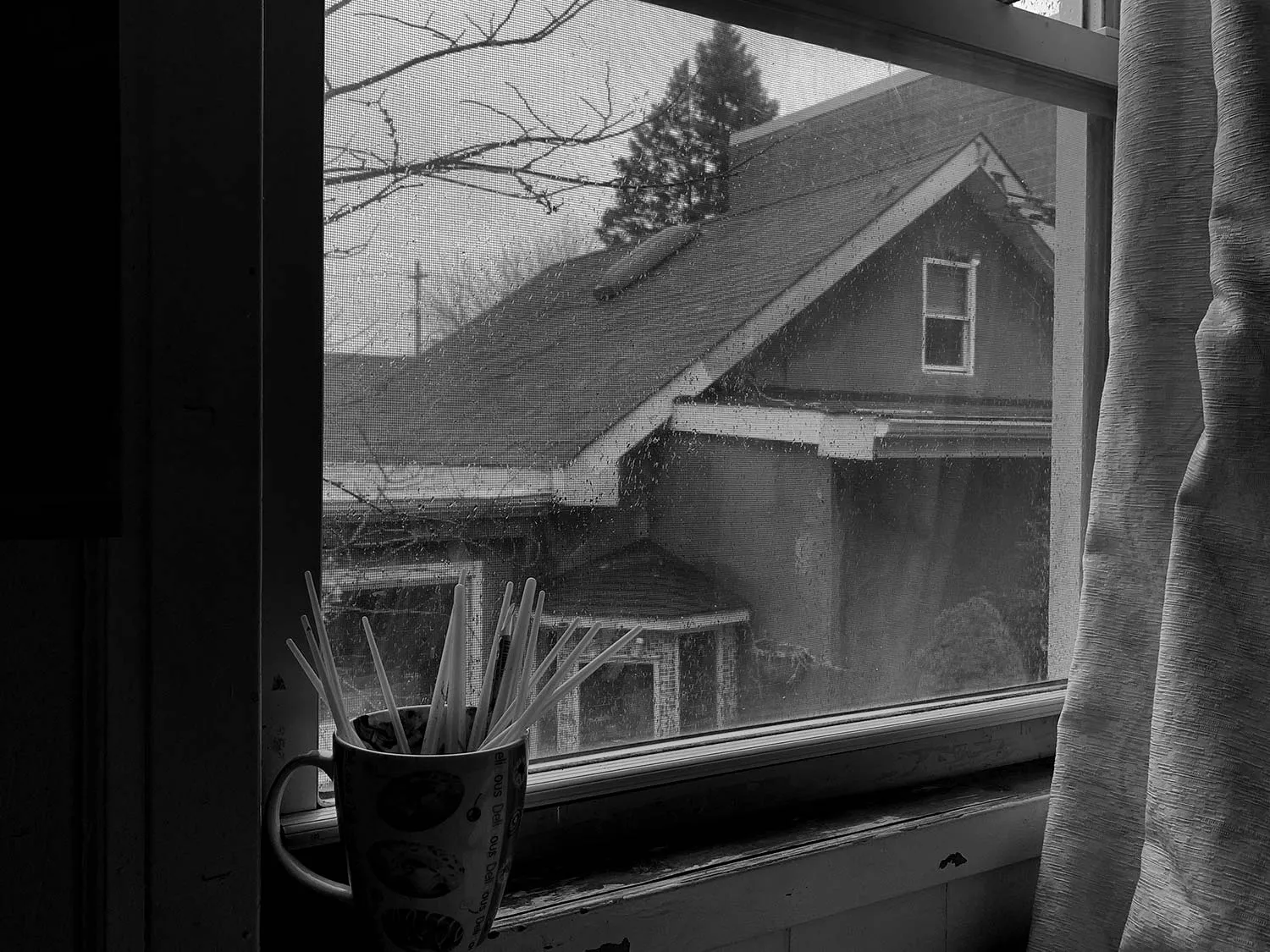 A house next door, as seen through a worn down window. 