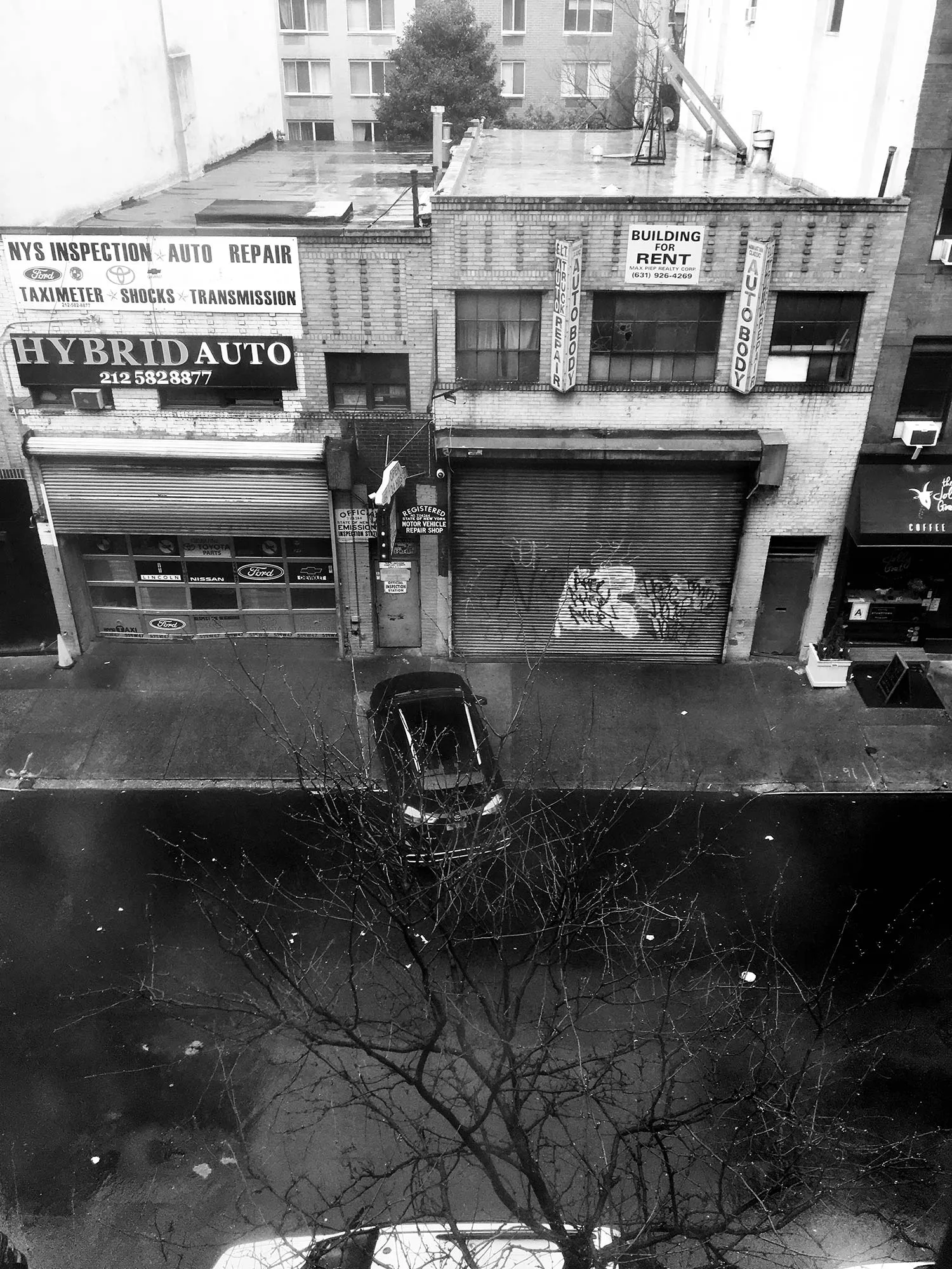 Black and white photo of the the front of commercial buildings